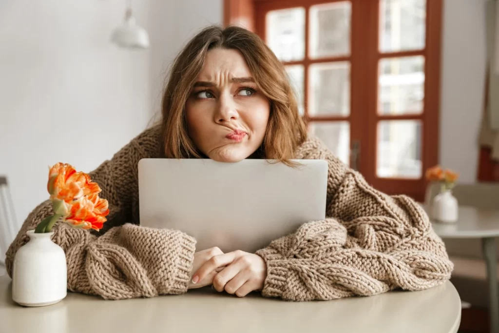 Confused girl with her laptop on the table.
