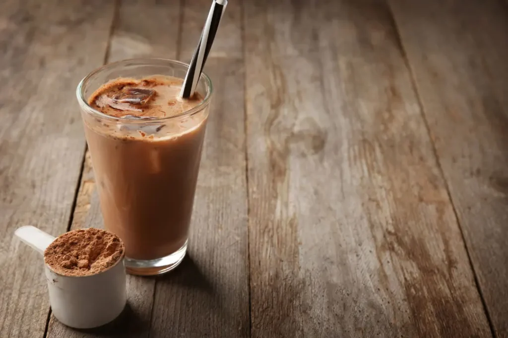 glass with a protein shake and powder scoop