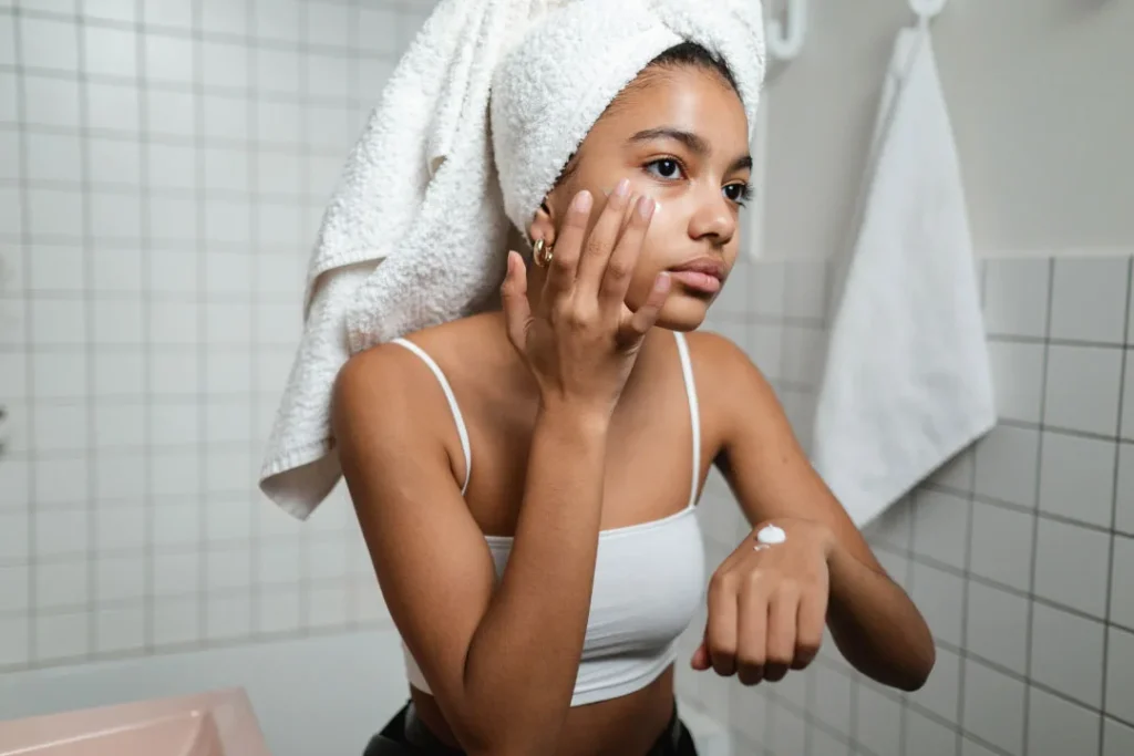 Lady applying cream on her face.